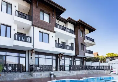 an apartment building with a swimming pool in front of it at St George Apartcomplex in Shkorpilovtsi