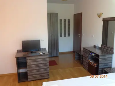 a living room with a flat screen tv and a desk at Adri Guest House in Nesebar