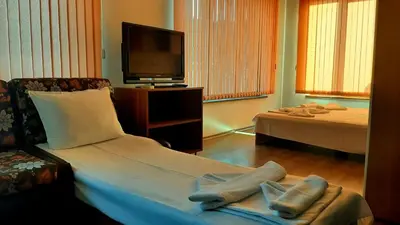a living room with a bed and a tv at Adri Guest House in Nesebar