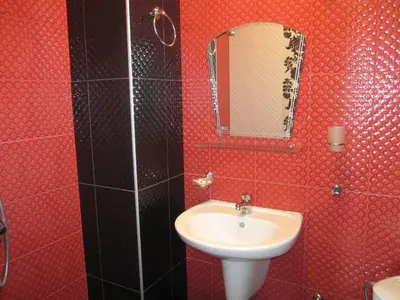 a red bathroom with a sink and a mirror at Neli Sea Villa in Sozopol