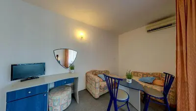 a room with a living room with a table and a television at Elmar Hotel in Kiten