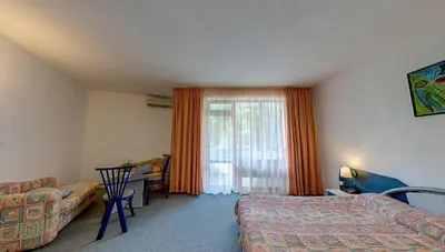 a bedroom with a bed and a table and a window at Elmar Hotel in Kiten