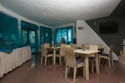 a dining room with tables and chairs and a fishtank at Elmar Hotel in Kiten