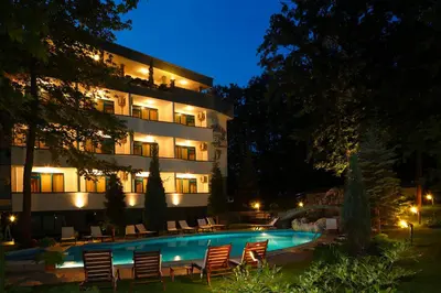 a hotel with a swimming pool at night at Elmar Hotel in Kiten