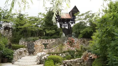 a garden with a gazebo and a stone wall at Sozopoli Hills Simeonov Apartments in Sozopol