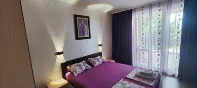 a bedroom with a purple bed and a window at Sozopoli Hills Simeonov Apartments in Sozopol
