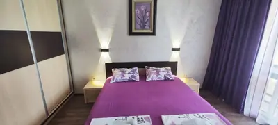a bedroom with a purple bed with two pillows at Sozopoli Hills Simeonov Apartments in Sozopol