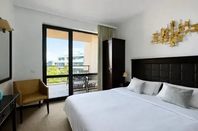 a bedroom with a bed and a chair and a window at ROYAL BEACH - Modern & Private Apartments in center Sunny Beach in Sunny Beach