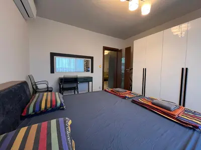 a bedroom with a bed and a desk in it at Botabara 312 Beach Front Apartment in Pomorie