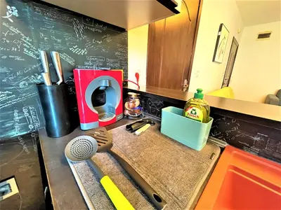 a kitchen counter with a sink and a chalk board at Botabara 312 Beach Front Apartment in Pomorie