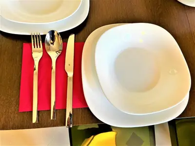 a table topped with white plates and utensils at Botabara 312 Beach Front Apartment in Pomorie