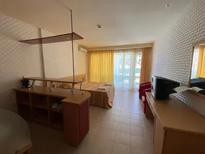 a living room with a room with a bed and a television at Miramar Front Beach Self Catering Apartments No Swim Pool Access in Sunny Beach