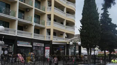 a tall building with a tree in front of it at Miramar Front Beach Self Catering Apartments No Swim Pool Access in Sunny Beach