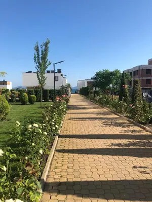 a cobblestone path in a park with flowers at Loli’s Beach Studio in Burgas City