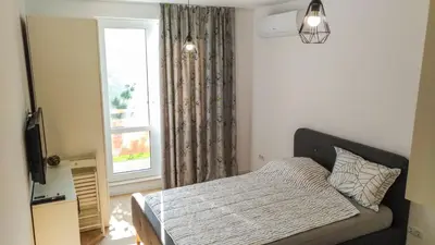 a bedroom with a bed and a window at Loli’s Beach Studio in Burgas City
