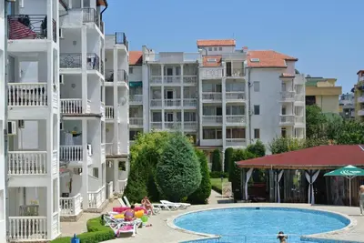a hotel with a swimming pool in front of tall buildings at Bravo 5 Apartments in Sunny Beach