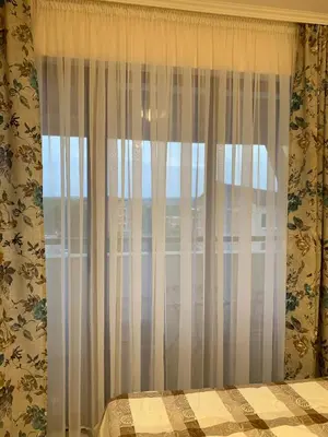 a bedroom with a window with white curtains at MM Complex Dimitrovi in Primorsko