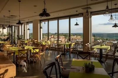 a restaurant with tables and chairs and large windows at Eco complex Zdravets near Varna in Zdravets