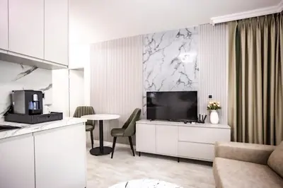 a living room with a television and a table at Onyx Beach Residence - Free Beach Access & Parking in Sveti Vlas