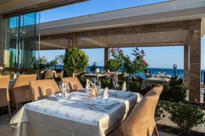 a restaurant with tables and chairs and a view of the ocean at Onyx Beach Residence - Free Beach Access & Parking in Sveti Vlas