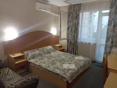 a hotel room with a bed and a window at Krasi Hotel in Ravda