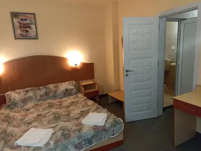 a hotel room with a bed and a bathroom at Krasi Hotel in Ravda