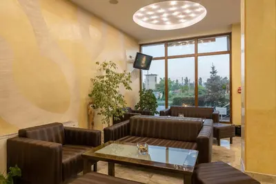 a waiting room with leather chairs and a table at Adamo Hotel in Varna City