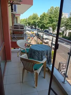 a table and chairs on a balcony with a view of a street at Panorama Vigo Nesebar in Nesebar