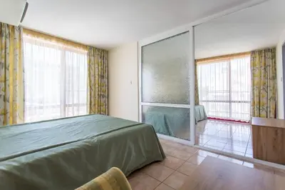 a bedroom with a bed and a large window at Hotel Longosa - All Inclusive in Sunny Beach