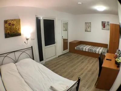 a small room with two beds and a desk at Samuil Apartments - Central Burgas in Burgas City