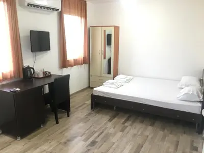 a bedroom with a bed and a desk and a computer at Samuil Apartments - Central Burgas in Burgas City