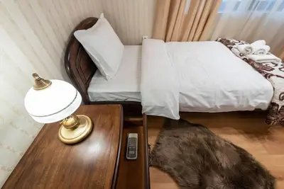 a bedroom with a bed and a table with a lamp at Vazov Residence , two bedroom top centre apartment in Varna City