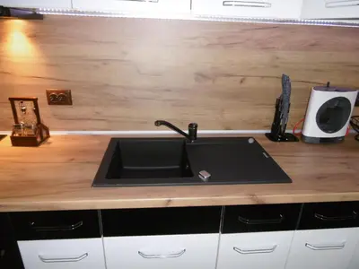 a kitchen with a sink and a wooden counter top at Апартамент Жекови in Tsarevo