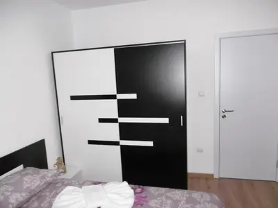 a bedroom with a black door and a bed at Апартамент Жекови in Tsarevo