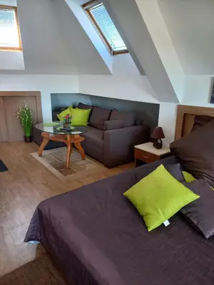 a bedroom with a bed and a couch and a table at Guest house Veneta in Sozopol