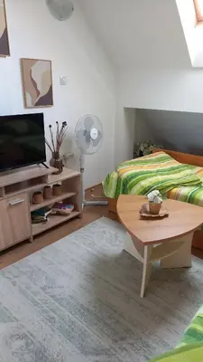 a bedroom with a bed and a tv and a table at Guest house Veneta in Sozopol