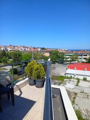a balcony with potted plants and a view of a city at Guest house Veneta in Sozopol