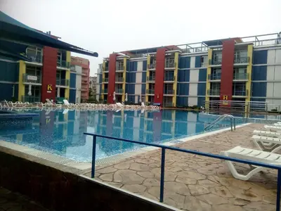 a large swimming pool with chairs and buildings at Studios in Complex Elit 4 in Sunny Beach