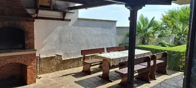 a table and bench under an umbrella on a patio at Sani Holiday Village in Sozopol