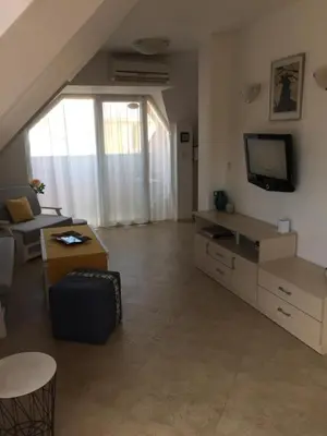 a living room with a couch and a tv at Studio Stoianovi in Nesebar