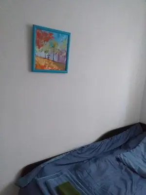 a painting hanging on a wall above a bed at Апартамент Термите in Varna City
