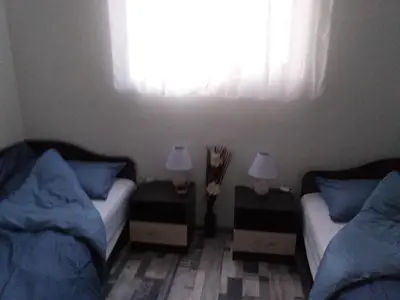 a bedroom with two beds and two lamps on tables at Апартамент Термите in Varna City