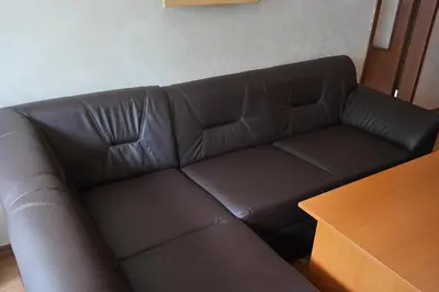 a brown leather couch in a room with a wooden table at Tanya Hotel in Sunny Beach