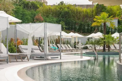 a pool with chairs and umbrellas next to a swimming pool at Siena Premium Retreat in Lozenets