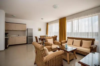 a living room with couches and tables and a kitchen at Arapya Sun Resort in Arapya