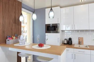 a kitchen with white cabinets and a wooden counter top at Niko's Apartments Deluxe in Nesebar
