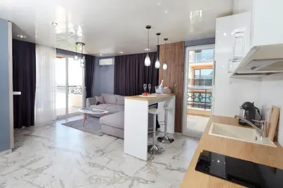 a kitchen and living room with a couch and a table at Niko's Apartments Deluxe in Nesebar