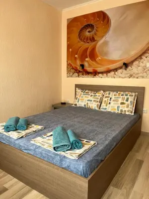 a bedroom with a bed with a painting on the wall at Апартамент Морска Звезда in Nesebar