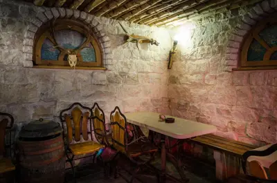 a table and chairs in a room with a stone wall at Kalypso Hotel in Primorsko