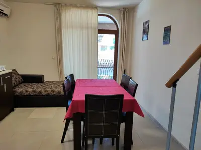 a dining room with a red table and chairs at Гардън Бийч - НЕДЯЛКОВИ in Sozopol